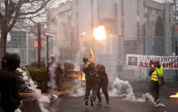 Un manifestant lance un cocktail Molotov à la préfecture française de Bastia le 13 mars 2022